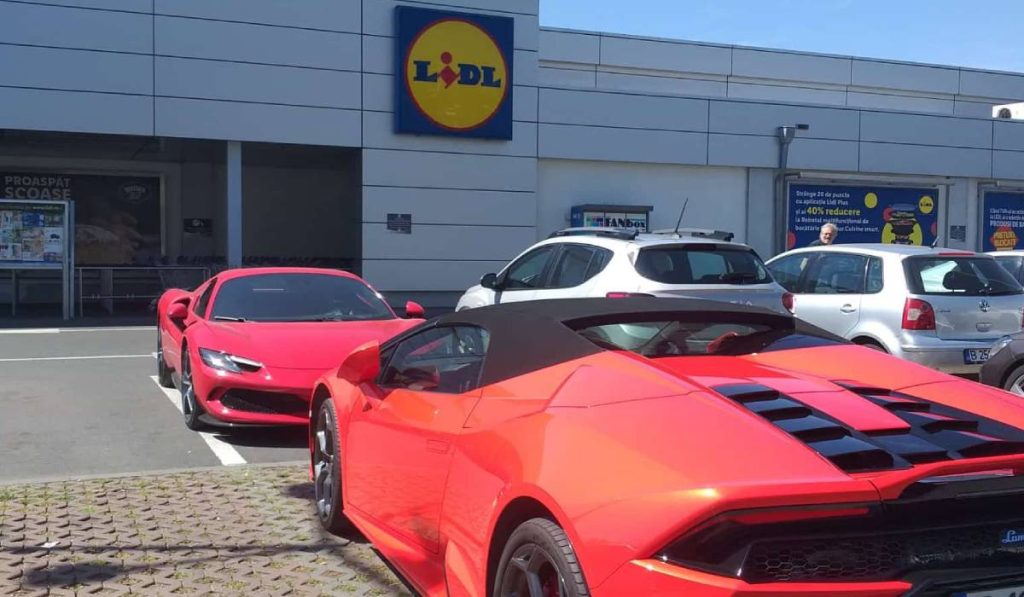 Lamborghini și Ferrari roșii parcate față în față la un Lidl din București