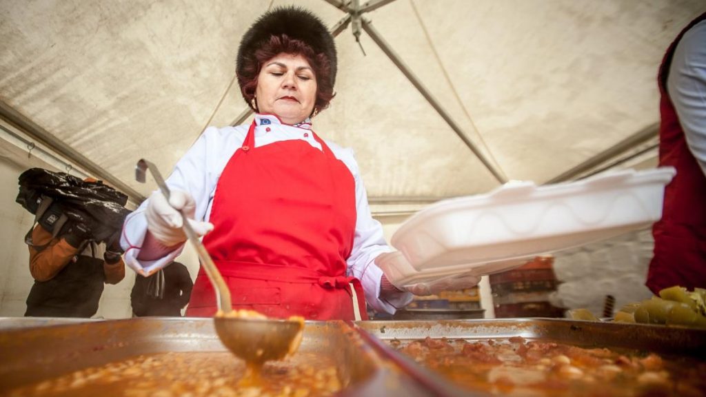 poza in care apare o femeie care pune intr-o caserola fasole cu ciolan de 1 decembrie